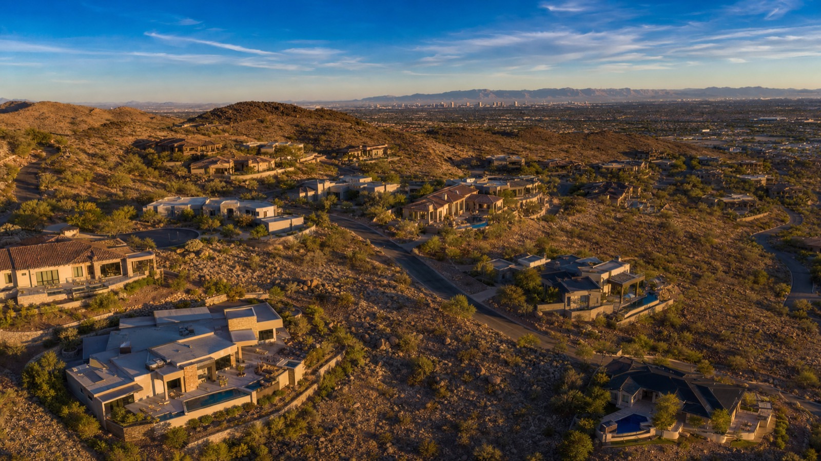 Calico Ridge Henderson hillside community streetscape with Mediterranean luxury estates and Strip view in distance