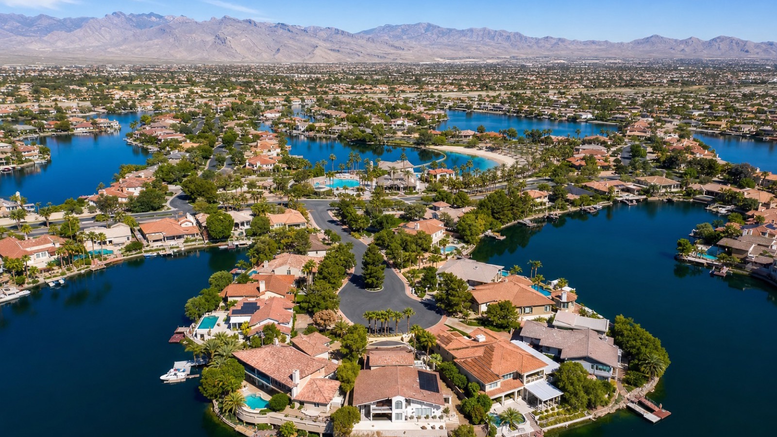 Desert Shores northwest Las Vegas private lake with lakefront homes and paddleboats at golden hour